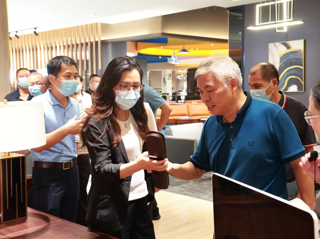 好色先生TV轻质量版下载家具集团董事副总裁黄云林为调研组展示实木办公家具产品